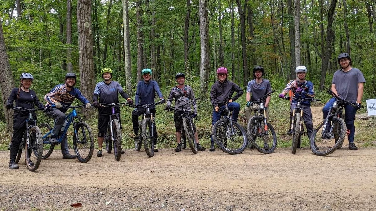 10 mountain bikers in a row with their bikes